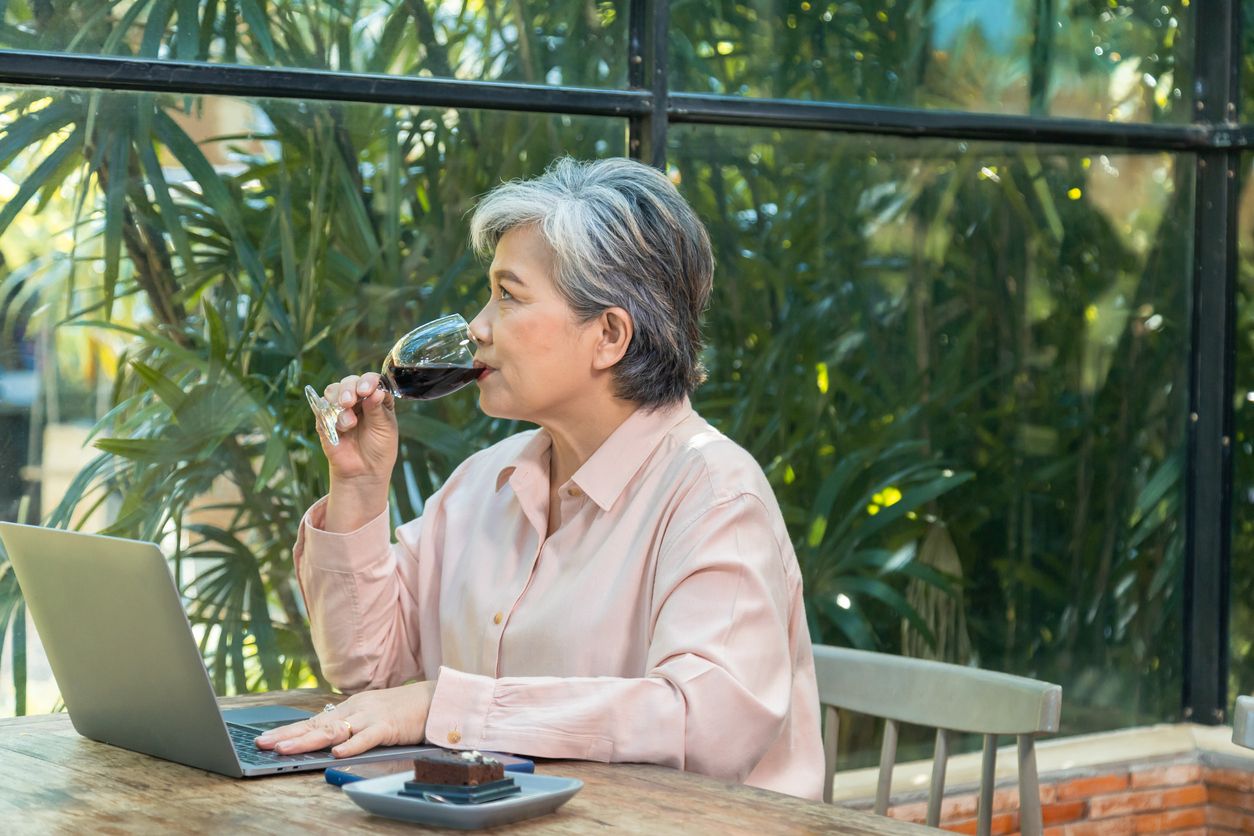 Una mujer mayor bebiendo vino