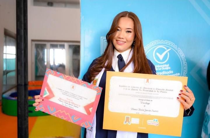 Blanca Paola García Suárez mostrando con orgullo su diploma de pregrado.