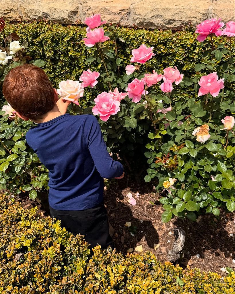 Archie Harrison mirando las rosas del jardín de su casa, en compañía de su madre y su hermana Lilibet