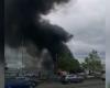 Se desata un infierno en un aparcamiento con varios vehículos en llamas mientras una enorme columna de humo llena el aire.